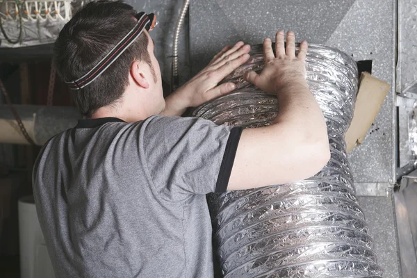 Technician cleaning air vent